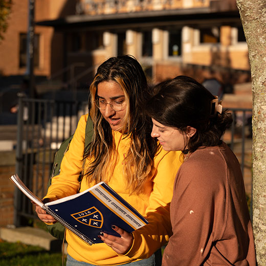 Two students looking at a notebook. Links to Donor-Advised Funds Two students looking at a notebook. Links to Donor-Advised Funds